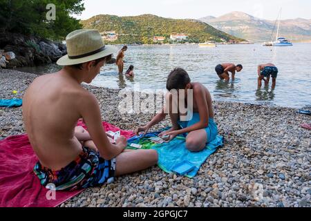 Croatie, Dalmatie, Iles Elaphites, Ile de Sipan, le port de Sudurad, joueurs de cartes sur une plage de galets Banque D'Images