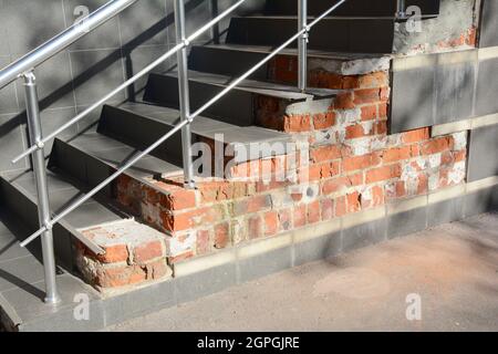 Maison cassée marche fondations avec des fuites d'eau à l'extérieur. La cage d'escalier endommagée doit être réparée. Banque D'Images