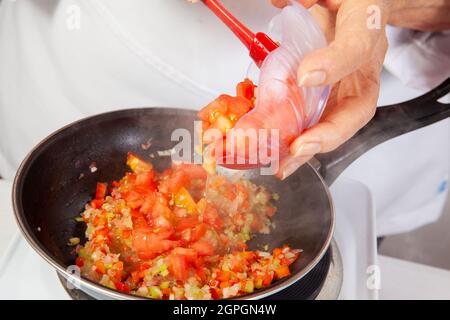 Préparation de la sauce traditionnelle colombienne hogao ou criollo (salsa criolla) à base d'oignons, de tomates, de poivrons et de coriandre Banque D'Images