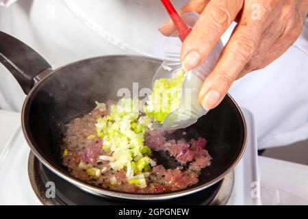 Préparation de la sauce traditionnelle colombienne hogao ou criollo (salsa criolla) à base d'oignons, de tomates, de poivrons et de coriandre Banque D'Images