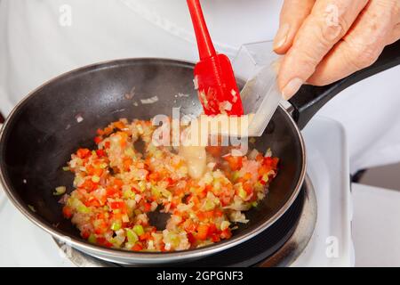 Préparation de la sauce traditionnelle colombienne hogao ou criollo (salsa criolla) à base d'oignons, de tomates, de poivrons et de coriandre Banque D'Images