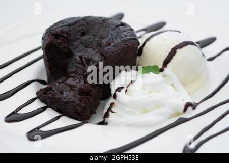Coulant au chocolat avec crème et glace à la vanille. Banque D'Images