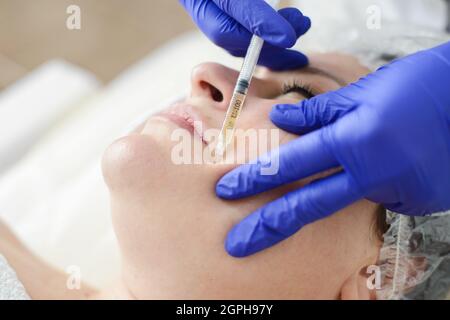 En mésothérapie avec aiguille dans un salon de beauté ou une clinique. Les cosmétiques ont été injectés au visage de la femme, portrait de près Banque D'Images