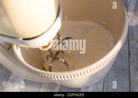 Étape par étape le processus de fabrication de la crème aigre. La crème aigre est fouettée dans un récipient mélangeur avec un fouet. Banque D'Images