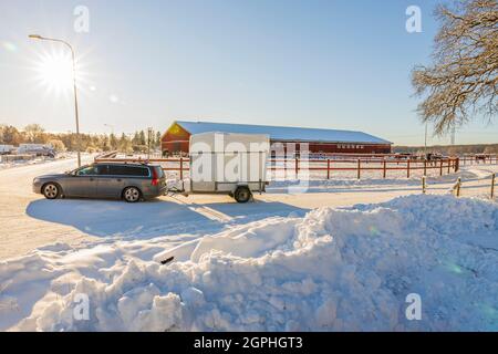 Belle vue sur le paysage d'hiver. Сar avec une remorque à cheval roulant sur route. Suède. Banque D'Images