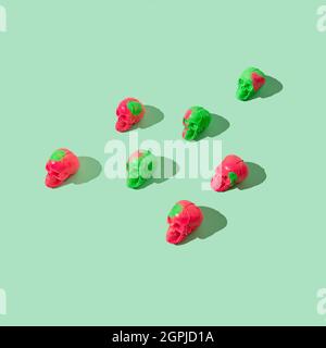 Un motif en vert et fuchsia sculptent sur un fond vert pastel. Concept créatif Halloween ou Day of the Dead. Arrang effrayant d'art pop coloré Banque D'Images