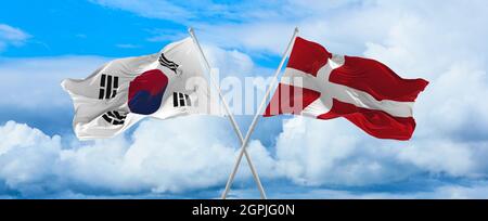 Drapeaux de la Corée du Sud et du danemark agitant dans le vent sur des mâts de drapeaux contre le ciel avec des nuages le jour ensoleillé. Symbolisant la relation, le dialogue entre deux co Banque D'Images