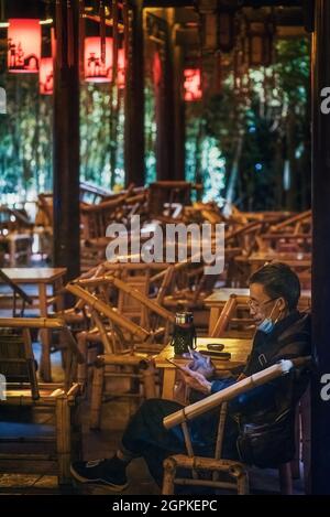Chengdu, province du Sichuan, Chine - 1 septembre 2021 : un homme qui a le thé dans l'ancien salon de thé Heming illuminé la nuit dans le parc des gens Banque D'Images