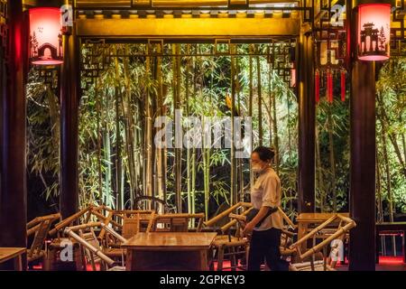 Chengdu, province du Sichuan, Chine - 1 septembre 2021 : serveuse dans l'ancienne maison de thé Heming illuminée la nuit dans le parc des gens Banque D'Images