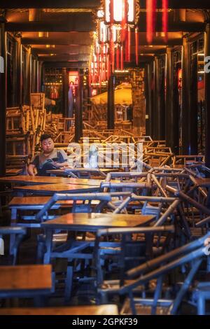 Chengdu, province du Sichuan, Chine - 1 septembre 2021 : un homme qui a le thé dans l'ancien salon de thé Heming illuminé la nuit dans le parc des gens Banque D'Images