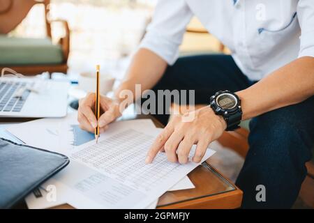 Administrateur homme d'affaires faisant un rapport, calculant le solde. Entreprise analysant les graphiques, les graphiques et les données de revenu sur le tableau. Banque D'Images