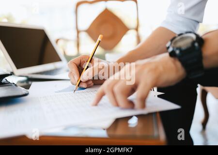 Administrateur homme d'affaires faisant un rapport, calculant le solde. Entreprise analysant les graphiques, les graphiques et les données de revenu sur le tableau. Banque D'Images