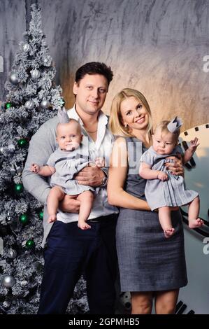 Une grande famille heureuse avec deux enfants dans l'intérieur de la maison du nouvel an sur le fond d'un arbre de Noël. Banque D'Images