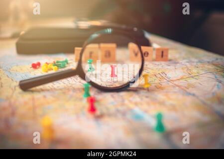 Une loupe avec des broches épinglées sur la carte. Punaise montrant l'emplacement d'un point de destination sur une carte. Concept de plan de voyage. Banque D'Images