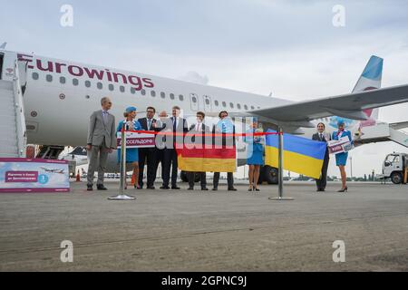 Ukraine, Kiev - 1er septembre 2021 : hôtesses et pilotes.Hôtesse tenant le drapeau de l'Allemagne.Le pilote sourit.Équipe.Avion Eurowings de la compagnie aérienne.Airbus A320-214 D-AEWU à l'aéroport. Banque D'Images