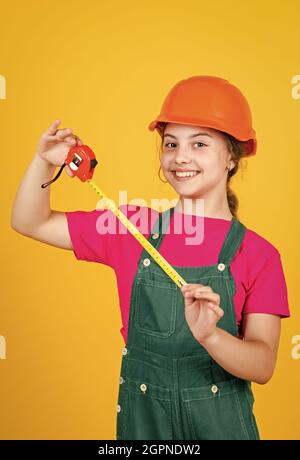 longueur. ouvrier de construction avec mètre ruban. Mignon enfant comme ouvrier de construction. Enfant répare la maison. Enfance heureuse. Auto-rétractable ruban en métal Banque D'Images