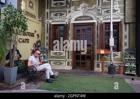 Une photo franche d'un homme assis à l'extérieur d'un café confortable dans le sud de Mumbai, en Inde. Architecture et point de repère de Mumbai. Banque D'Images