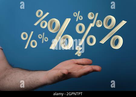 rendu 3d des symboles de pourcentage beige sur une main sur fond bleu Banque D'Images