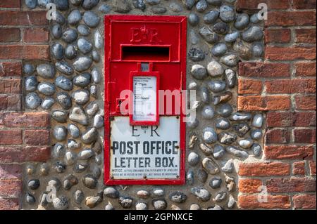 Une ancienne boîte postale rouge de la poste royale d'urgence est fixée dans un mur de silex à Norfolk au Royaume-Uni Banque D'Images