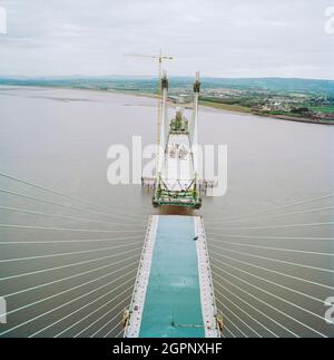 Vue à l'ouest depuis le sommet du second Severn Crossing pendant sa construction, montrant les travaux en cours pour joindre les unités sur le pont en dessous. Le second Severn Crossing a pris quatre ans à construire et était un projet conjoint de génie civil entre Laing civil Engineering et la société française GTM. Les travaux ont commencé en avril 1992 et la cérémonie d'ouverture a eu lieu plus tard le 5 juin 1996. Le passage à niveau est un pont suspendu par câble qui s'étend sur plus de 5000 mètres à travers la rivière Severn reliant l'Angleterre et le pays de Galles, à 3 miles en aval du pont Severn qui a ouvert en 1966. Banque D'Images