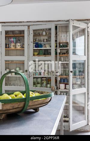 Cuisine commode avec céramiques anciennes et verrerie dans la ferme Sussex, Royaume-Uni Banque D'Images