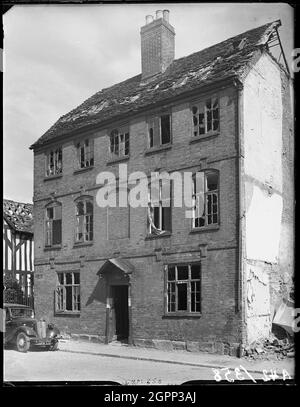 27-28 Greyfriars Lane, Coventry, Coventry, Coventry, 1941. L'élévation frontale de 27 et 28 Grayfriars Lane et l'accès à la Cour 6, montrant des preuves de dommages causés par la bombe. Le centre-ville de Coventry a été dévasté par des raids aériens en 1940. Sur cette photo, il est possible de voir une partie du bois encadré à l'extrémité sud de l'hôpital Ford qui, malgré la souffrance d'un coup direct a été restauré en 1953. Numéro 27 &amp; 28 Greyfriars Lane a également subi de graves dommages et a été démoli. Le site est maintenant occupé par des appartements de retraite. Banque D'Images