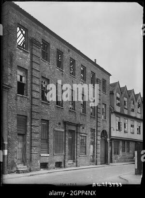 Norfolk Iron Works, rue Coslany, Norwich, Norfolk, 1942. L'élévation frontale du 24, rue Coslany, montrant des dégâts causés par la bombe, avec le numéro 22 visible en arrière-plan. Les numéros 22 et 24, rue Coslany, faisaient partie des Norfolk Iron Works, des locaux de Barnard's Limited qui étaient des fabricants de filets. Le logement moderne occupe maintenant le site. Banque D'Images