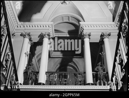 La Maison Mansion, High Street, Doncaster, 1942. Vue intérieure sur le hall d'entrée de Mansion House, donnant sur l'escalier. La résidence mayonnaise a été construite pour la Doncaster Corporation entre 1746 et 1748 par James Paine, avec des ajouts effectués entre 1801 et 1805 par William Lindley. Le hall d'entrée est doté d'un grand escalier impérial, ou d'un double escalier, avec des balusters en fer simple et en fer à rouleau. Au cours du premier atterrissage se trouve une ouverture vénitienne avec quatre paires de colonnes corinthiennes soutenant les corniches. Le hall supérieur derrière est orné de lambris sur les murs et d'un plafond incurvé en CO moulé Banque D'Images
