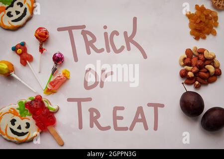 Lettrage de concept Trick or Treat. Aliments sains et malsains en comparaison: Alternative aux bonbons et aux bonbons - noix, fruits et fruits secs. Copier l'espace. Photo de haute qualité Banque D'Images