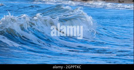 Vagues se brisant sur la rive au large de la plage à Rhosneigr sur Anglesey, au nord du pays de Galles, au Royaume-Uni Banque D'Images