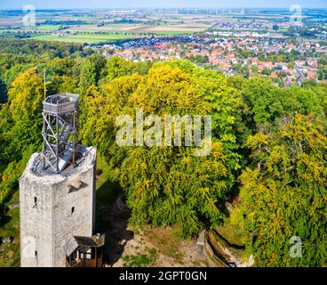 Vieux château ruines avec une plate-forme d'observation en bois devant une forêt dense et la périphérie d'une banlieue en arrière-plan Banque D'Images