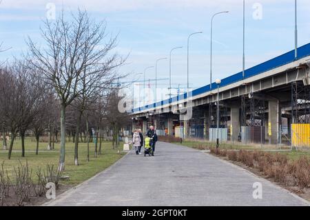 POZNAN, POLOGNE - 08 mars 2015 : les gens qui marchent sur un sentier asphalté le long d'un pont dans le parc de Rataje en Pologne Banque D'Images