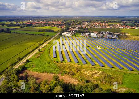 Vue aérienne d'une grande centrale solaire avec panneaux solaires sur le bord d'un village en Allemagne Banque D'Images