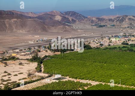 Vue aérienne d'une vallée verdoyante et de l'aéroport de Nazca, Pérou. Banque D'Images