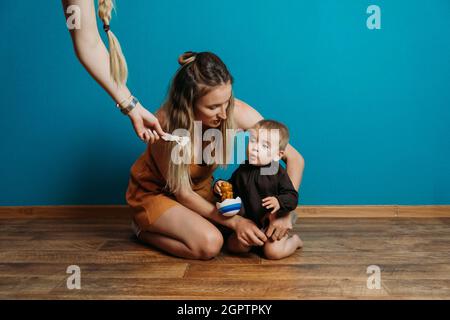 Mode bébé, choisissez la robe et les accessoires. Maman habille la petite petite fille de bébé à la maison. Mère et petite fille de mode bébé Banque D'Images