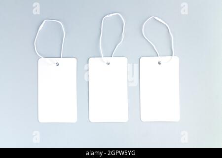 Jeu de trois étiquettes vierges en papier blanc ou étiquettes de prix sur fond gris Banque D'Images