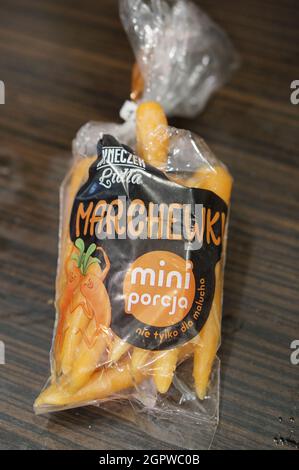 POZNAN, POLOGNE - 15 juillet 2017 : un sac de mini carottes polonaises dans un emballage plastique sur une table en bois Banque D'Images