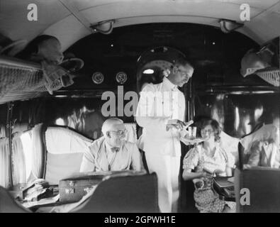 Photo vintage vers 1935 d'un steward servant des boissons à bord d'un avion de ligne Imperial Airways Handley page HP 42 sur l'Afrique. Les avions HP 42 étaient des avions de ligne biplans commerciaux à quatre moteurs à longue portée conçus et fabriqués par la compagnie aérienne britannique Handley page Banque D'Images