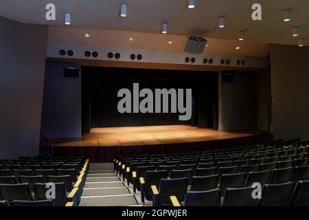Auditorium vide avec scène éclairée et rideau noir Banque D'Images