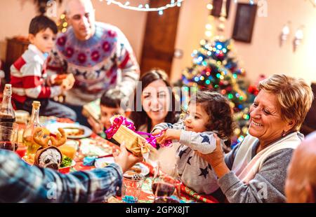 Grande famille multi-génération s'amuser à la fête de noël - vacances d'hiver x mas concept avec les parents et les enfants manger ensemble cadeau d'ouverture Banque D'Images