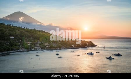 Paysage de l'île de Bali côte nord au coucher du soleil, avec le sommet du volcan du Mont Agung et les pentes de la forêt, et la mer de Java, depuis le sommet de la colline près d'Amed, Bali, Indo Banque D'Images