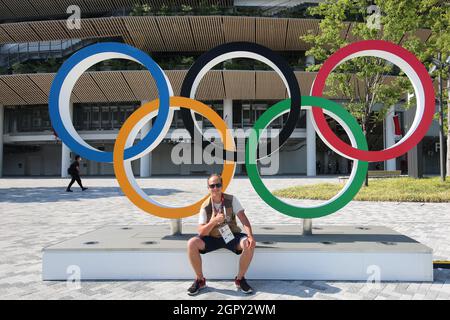 23 JUILLET 2021 - TOKYO, JAPON : le photographe officiel Mickael Chavet pose devant les anneaux olympiques avant la cérémonie d'ouverture du Tokyo 20 Banque D'Images