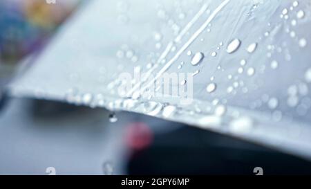 gros plan des gouttes de pluie qui s'écoulent d'un parapluie transparent Banque D'Images