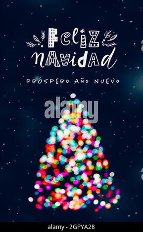Feliz Navidad salutation avec arbre de Noël fait de lumières de Noël colorées défocused à la nuit de neige et le lettrage drôle Banque D'Images