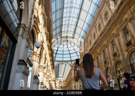 Femme touriste prenant des photos avec le téléphone de l'appareil photo de la galerie Vittorio en Italie à côté du Duomo di Milano Banque D'Images
