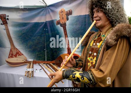 Moscou, Russie. 22 juillet 2017 l'homme portant le costume national de Bashkir joue l'instrument de musique national de Quray pendant les célébrations de Sabantuy, une fête ethnique des Bashkirs et des Tatars, dans le musée de la réserve naturelle et historique de Kolomenskoye, à Moscou, en Russie Banque D'Images