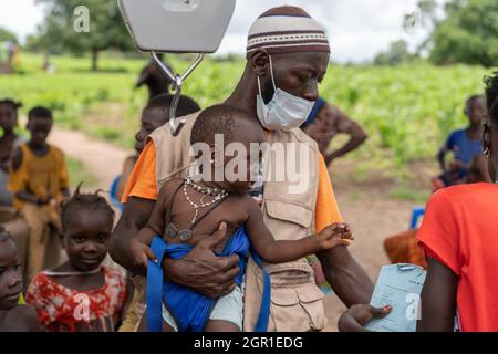 Basse, Gambie. 20 août 2021. Un agent de santé du Centre de réadaptation et d'éducation contre la malnutrition pèse un des enfants.pendant la pandémie de Covid19, les mesures de santé menées par les hôpitaux et les centres de santé ont été limitées à l'identification et au traitement des cas liés au covid-19. Maintenant que les restrictions s'assouplissent, des mesures comme le dépistage visant à cibler et à traiter les cas graves de malnutrition dans les villages ruraux de Gambie peuvent être reprises. (Credit image: © Aran Rodriguez/SOPA Images via ZUMA Press Wire) Banque D'Images