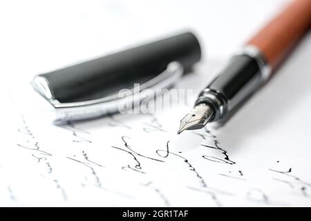Stylo-plume nostalgique et capuchon sur une lettre manuscrite illisible ou un manuscrit, gros plan avec une mise au point sélectionnée et une faible profondeur de champ Banque D'Images