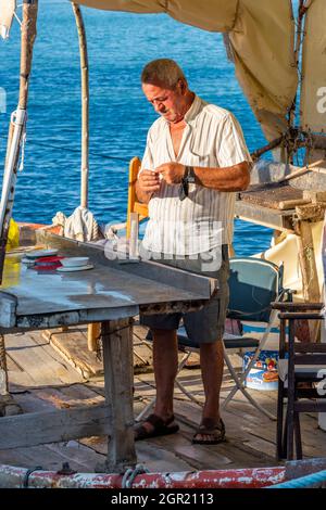 pêcheur grec travaillant sur son bateau dans le port de la ville de zakynthos sur zante grèce. pêcheur dans la méditerranée travaillant à une table de préparation. Banque D'Images