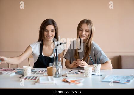 Vue de face de quatre belles femmes caucasiennes à l'atelier d'art. Un jeune enseignant enseigne le dessin Banque D'Images